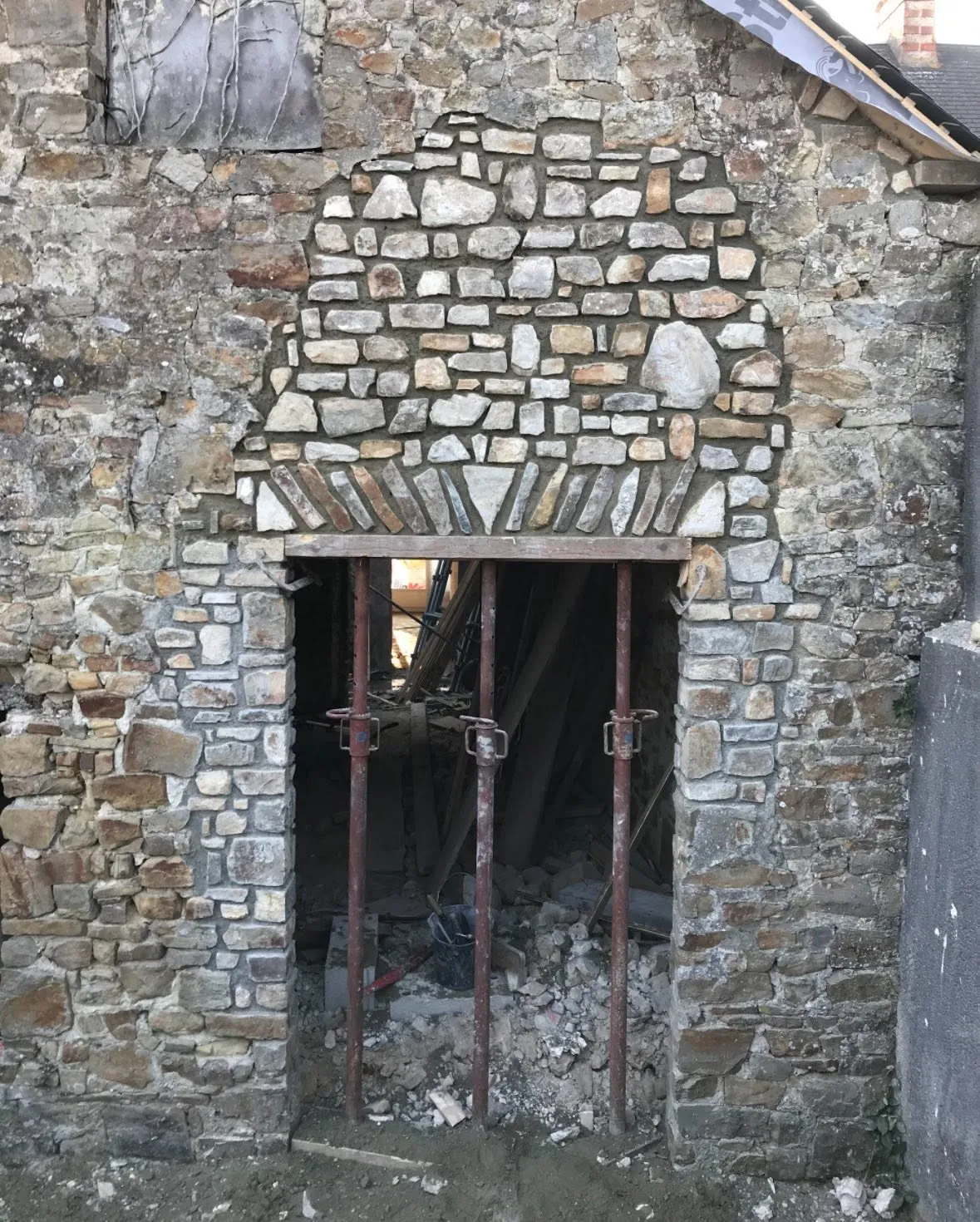Création d'une ouverture dans un mur en pierre de longère, avec arc de décharge en briques et étaîement