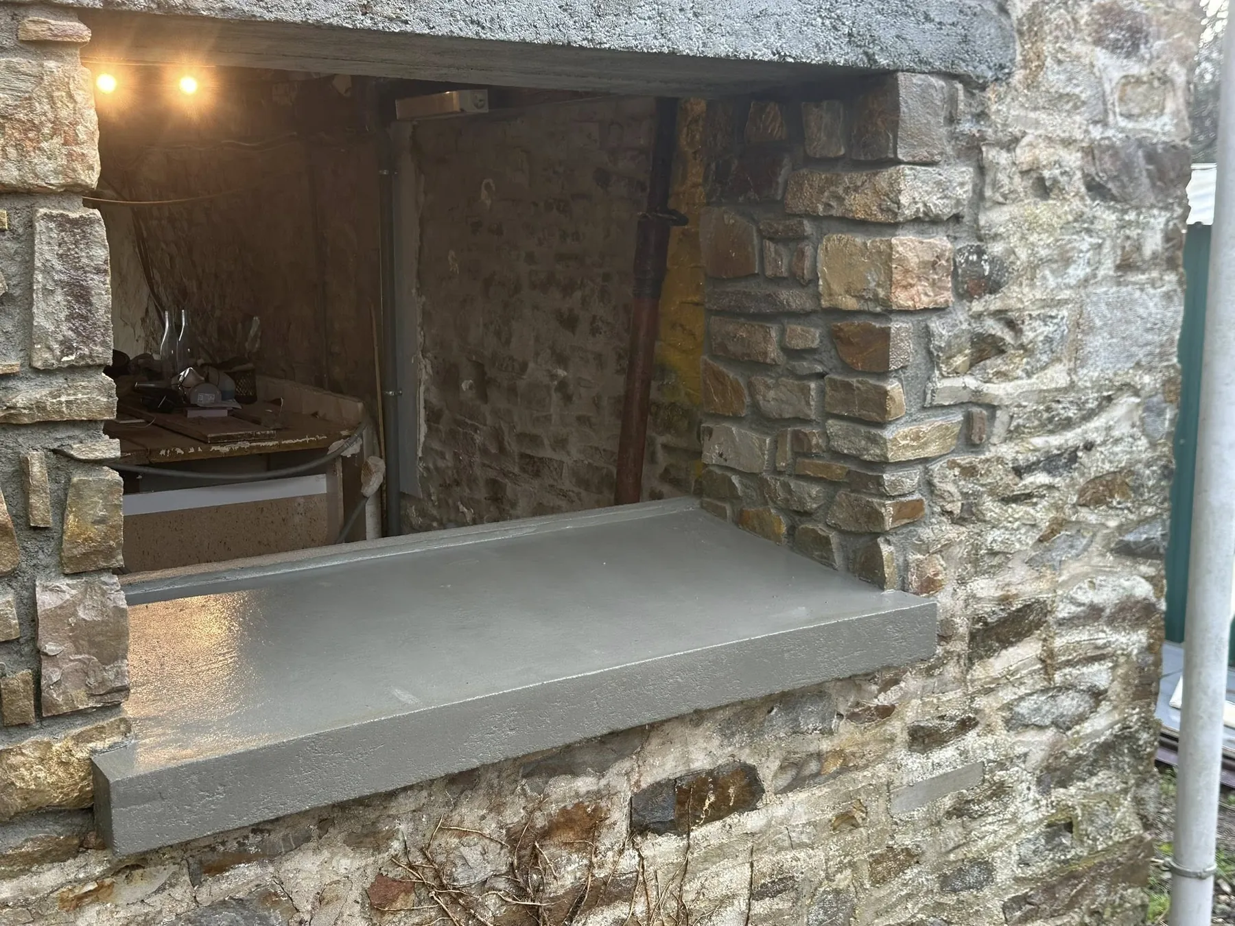 Appui de fenêtre en béton posé dans une ouverture de mur en pierre
